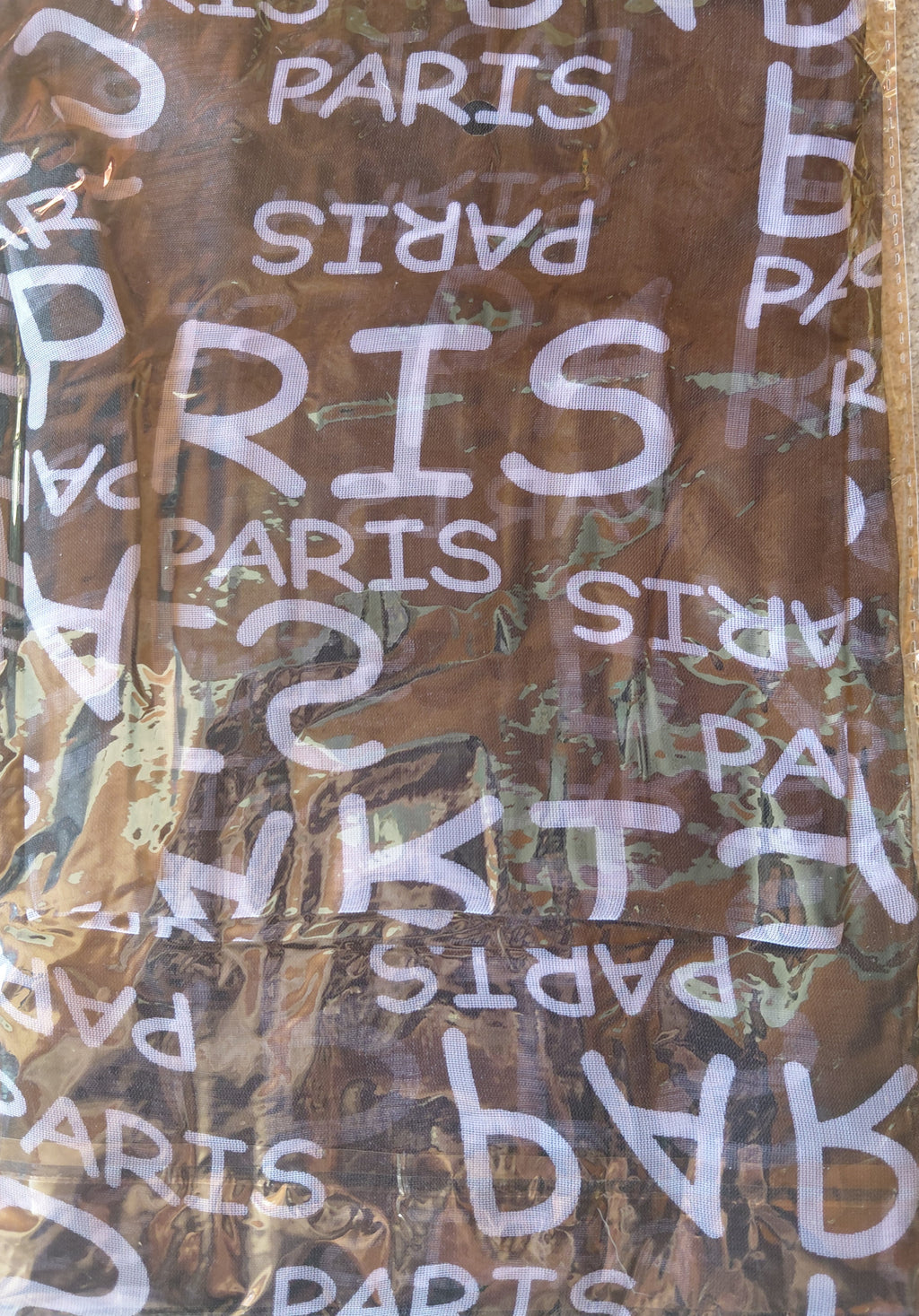 Foulard en mousseline marron avec imprimé écriture Paris blanc, gros plan sur le tissu