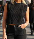 Pull en tricot sans manches col rond noir, motif torsades losanges, porté en ville avec jean noir