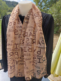 Foulard en mousseline rose poudré imprimé écriture Paris porté sur mannequin, style léger et féminin